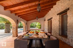 una sala da pranzo all'aperto con tavolo e frutta di Villa Fantaxat by Abahana Villas a Benissa