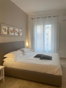 a bedroom with a large white bed with a window at San Domenico Residence by BADIA NUOVA in Trapani