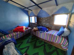 IzilaneにあるGîte de montagne Azilaneのベッド2台と窓が備わる客室です。