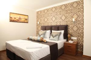 ein Schlafzimmer mit einem großen Bett und einer Wand in der Unterkunft Safir Hotel in Istanbul
