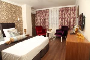 ein Hotelzimmer mit einem Bett und zwei roten Stühlen in der Unterkunft Safir Hotel in Istanbul
