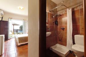 uma casa de banho com um chuveiro, um WC e um lavatório. em Hotel Apollon Corfu em Paleokastritsa