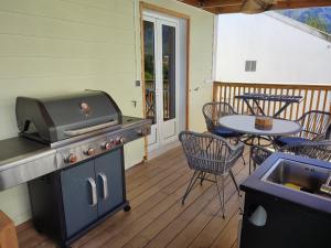 a patio with a grill and a table on a deck at La Belle Créole in Cilaos