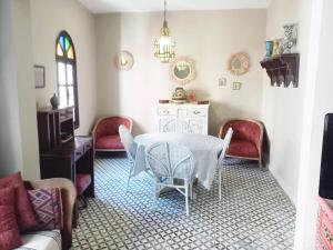 uma sala de jantar com uma mesa e duas cadeiras em Dar Nadia em El Jadida