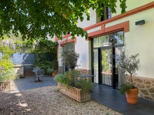 a patio with plants and a table in front of a building at Le Clos de la Pomponnette in Pomponne