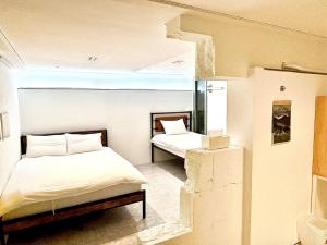 1 dormitorio con 2 camas y ventana. en Look Home Guesthouse, en Seúl