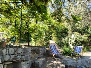 two blue chairs sitting in a yard next to a stone wall at le finestre sul mare in Conversano