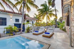 eine Terrasse mit 2 Liegestühlen und einem Pool in der Unterkunft Coral Laguna in Laguna Marina in Kralendijk