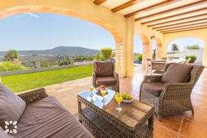 a patio with chairs and a table with drinks on it at Villa Fortezza by Abahana Villas in Benitachell