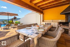 a dining room with a table and chairs and a pool at Villa Fortezza by Abahana Villas in Benitachell