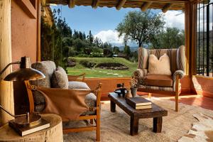 ein Wohnzimmer mit 2 Stühlen, einem Tisch und einem Fenster in der Unterkunft Cuesta Serena Boutique Hotel in Huaraz