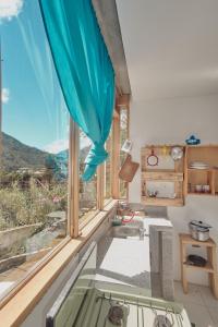 a kitchen with a large window with a view at Backpackers-balcones-river-lodge in Baños
