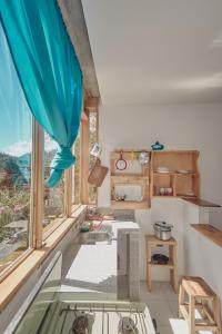 a kitchen with a large window and a sink at Backpackers-balcones-river-lodge in Baños