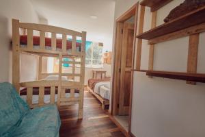 a room with two bunk beds and a bed at Backpackers-balcones-river-lodge in Baños