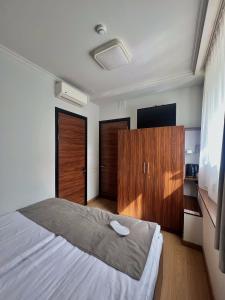a bedroom with a large bed and wooden cabinets at Mashtots Hotel in Yerevan