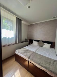 a bedroom with a large bed with a large window at Mashtots Hotel in Yerevan