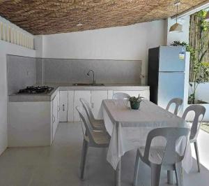 a kitchen with a table and chairs and a refrigerator at Lio Palm Villas in Langi-langiban