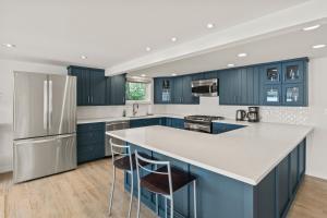 cocina con armarios azules y encimera blanca en Luxury Conesus Lakeside Dock Modern Amenities, en Livonia