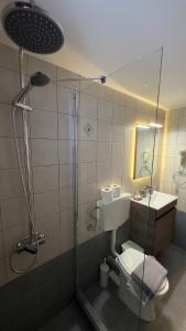 La salle de bains est pourvue de toilettes, d'un lavabo et d'une douche. dans l'établissement Aegean Balcony, à Áno Meriá