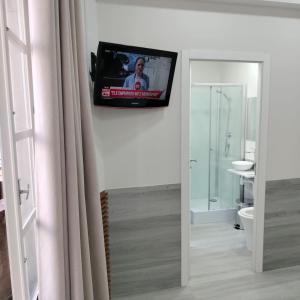 uma televisão pendurada numa parede numa casa de banho em Saboresgelados Alojamento Local em Braga
