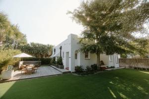 een huis met een tuin met groen gras bij Villa Marguerita by WB Abodes in Wrightsville Beach