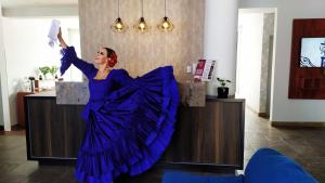 Una mujer con un vestido azul bailando en una habitación en Mirador del Monasterio, en Arequipa