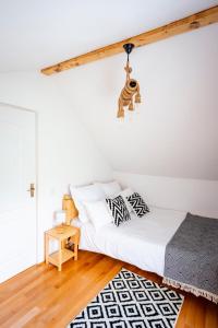 Vaideeni的住宿－Cerdacul din Livada，一间卧室配有一张床铺,天花板上挂着一只猴子
