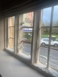 una ventana con vistas a un coche aparcado en una calle en The Fox & Hounds Inn en Dorchester