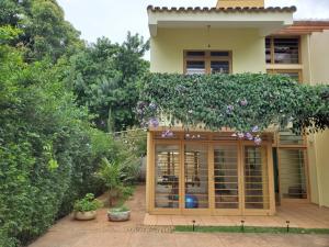 a building with a garden with purple flowers at Casa 11 in Campinas