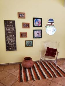 um quarto com uma cadeira e fotografias na parede em Casa 11 em Campinas