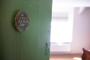 una puerta con un cartel que lee el vestido dorado en ella en The Fox & Hounds Inn en Dorchester