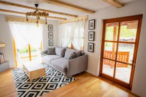a living room with a couch and a window at Cerdacul din Livada - Căsuța din Livadă in Vaideeni