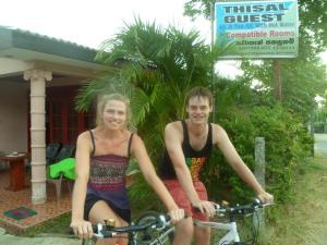 een man en een vrouw op een fiets bij Thisal Guest House in Polonnaruwa