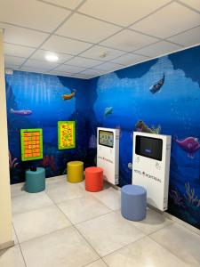 a room with an aquarium with two machines and a tv at Hotel Montreal in Bibione