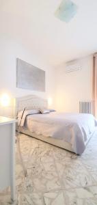 ein weißes Schlafzimmer mit einem großen Bett und einem Tisch in der Unterkunft Angela's Apartment. Elegant two bedroom house in Irsina in Irsina