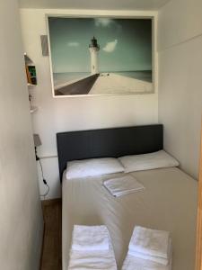 Cette chambre comprend un lit avec une photo de phare. dans l'établissement Bel appartement avec emplacement idéal, à Saint-Laurent-du-Var