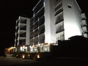 un grande edificio bianco con luci accese di notte di Hotel Vienna a Herceg-Novi