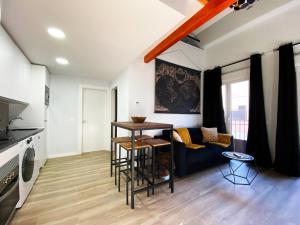 cocina y sala de estar con mesa y sofá en Las Barajas de Saturno en Madrid
