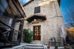 a stone building with a wooden door and a porch at AFFITTACAMERE RISTORANTE GUAITA SANT'EUTIZIO in Preci