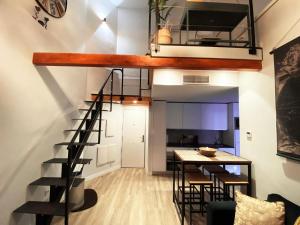 een loft appartement met een trap en een tafel bij Las Barajas de Saturno in Madrid