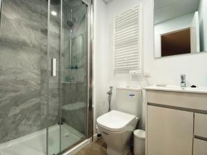 een badkamer met een douche, een toilet en een wastafel bij Las Barajas de Saturno in Madrid
