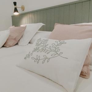 una cama blanca con un diseño floral. en CASA UMBRAL DE LA MEZQUITA - a menos de 50 metros de la Mezquita Catedral, en Córdoba