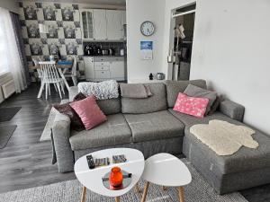 uma sala de estar com um sofá e uma mesa em Viihtyisä rivitalokolmio autopaikalla em Kangasala