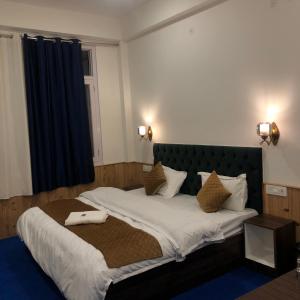 1 dormitorio con 1 cama grande y cabecero verde en Kheer Bhawani Villa en Kulu