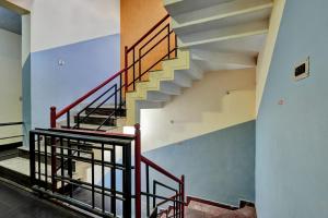 a staircase in a building with red railing at OYO Flagship Jashwanth Residency in Mysore