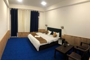 1 dormitorio con 1 cama y alfombra azul en Kheer Bhawani Villa en Kulu