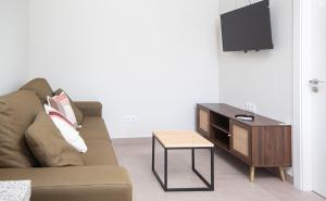 ein Wohnzimmer mit einem Sofa und einem Tisch in der Unterkunft AG Casa do Ramon en Playa Razo con patio exterior in A Coruña