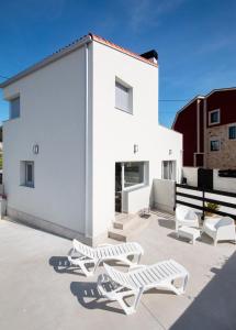 ein weißes Haus mit weißen Stühlen und einem Gebäude in der Unterkunft AG Casa do Ramon en Playa Razo con patio exterior in A Coruña