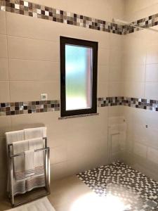uma casa de banho com uma janela e um toalheiro. em Quinta dos Sonhos em Aldeia dos Fernandes