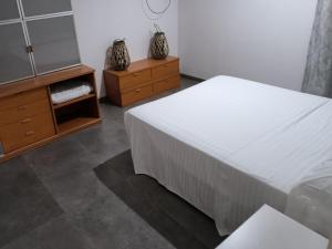 um quarto com uma cama, uma cómoda e um espelho em Chaletpiscina em Benicarló